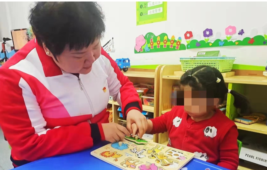汪媛媛正在为残疾儿童进行康复训练