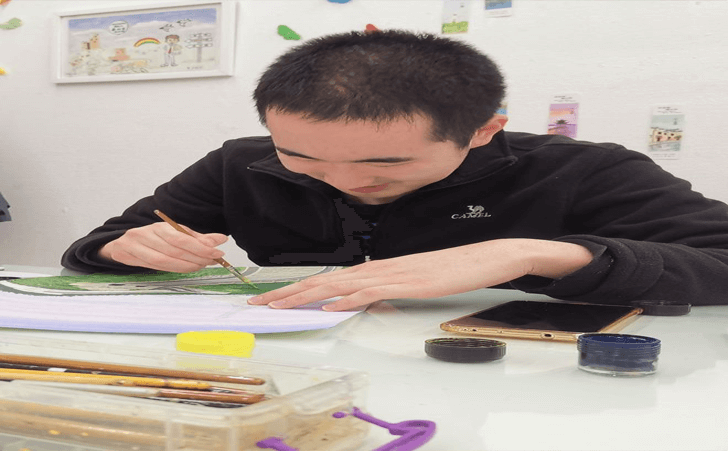 康睿在北京外研书店中他的专属画室里画画