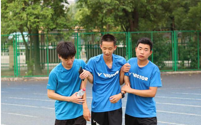 团队成员搀扶十堰市特殊教育学校跑完5000米的学生