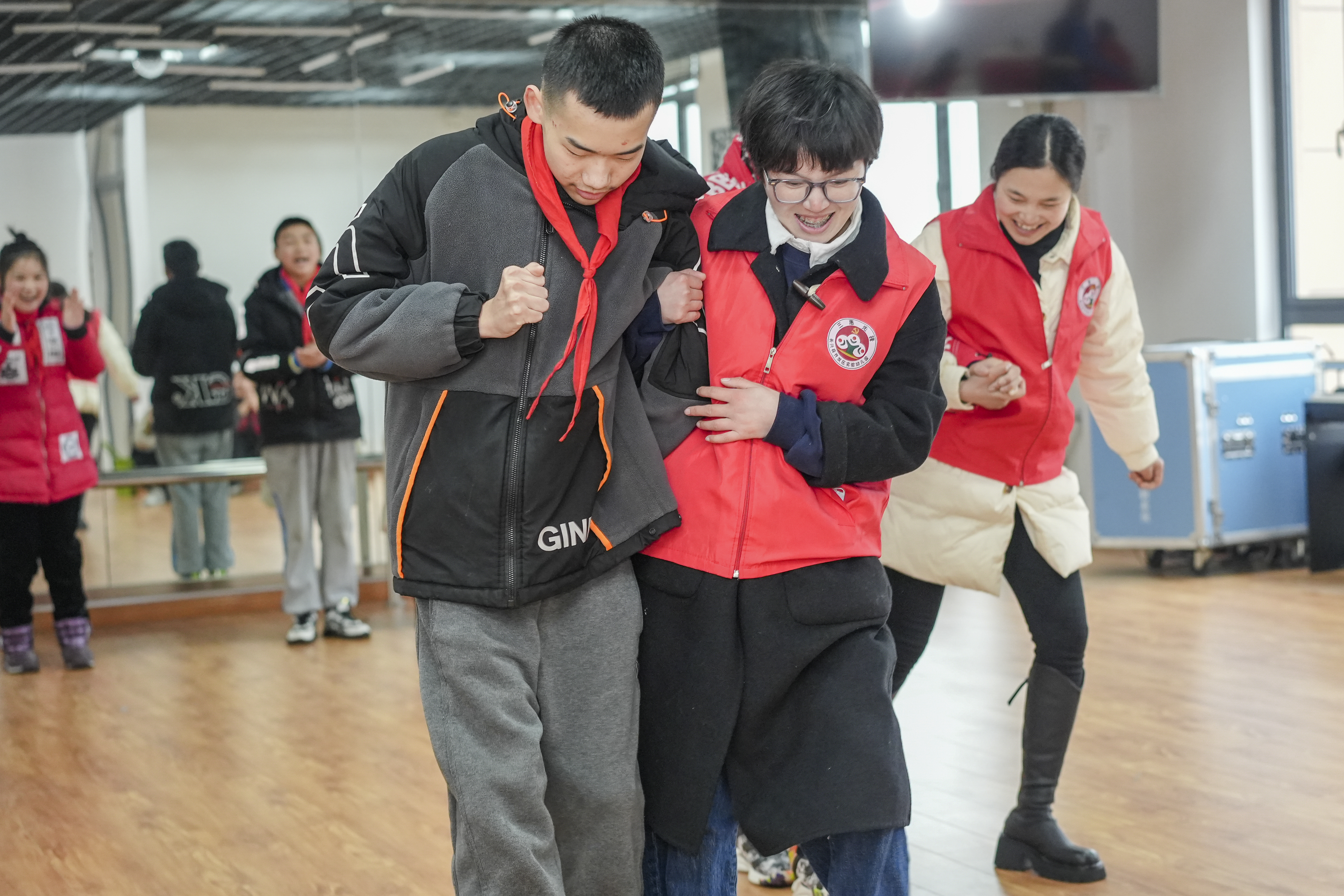 浙江省湖州市长兴县培智学校内，孩子们和党员教师一起进行“两人三足”游戏。 