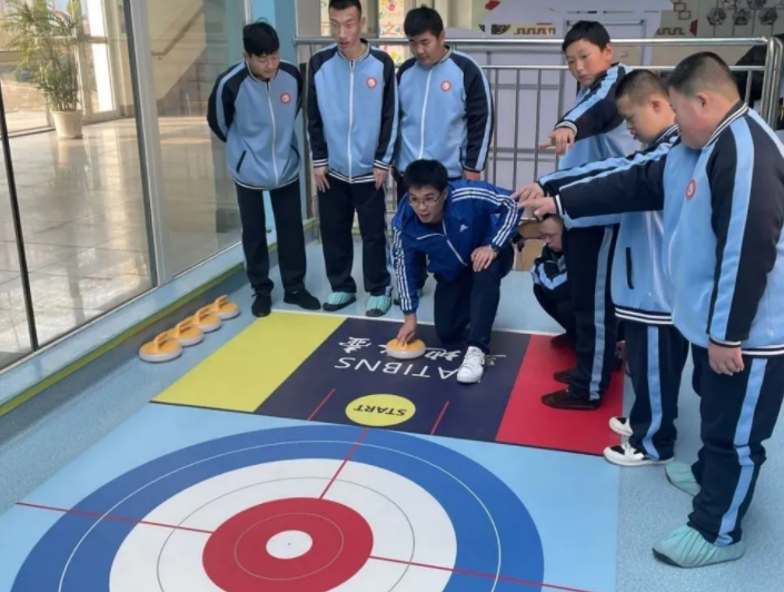 青岛胶州市特殊教育中心学校教师指导学生练习旱地冰壶。