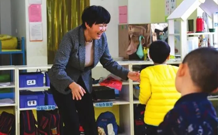 家嘉康复训练中心创办人王喜南在教室里陪孩子们玩耍
